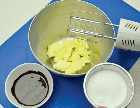 1. Rozměklé máslo vyšlehejte s krupicovým cukrem a tenkým pramínkem do pěny přilijte rozehřátou vlažnou hořkou čokoládu