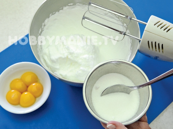 1. Z oddělených bílků vyšlehejte pevný sníh a po lžících do něj zapracujte krupicový cukr a pak žloutky (jeden po druhém)
