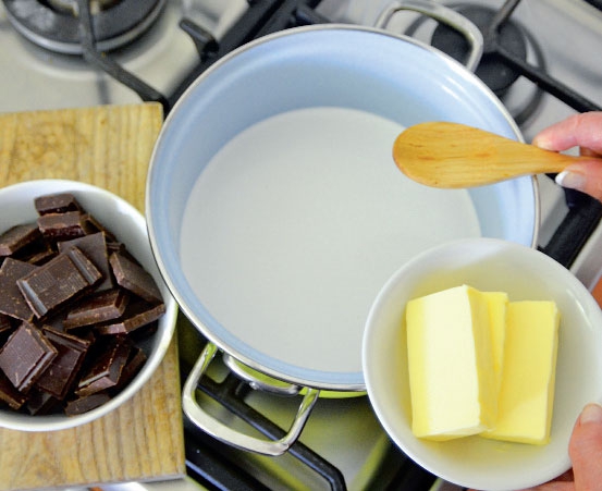 1. Jako první připravte krém: Smetanu zahřejte téměř k varu a rozpusťte v ní máslo a čokoládou. Vymíchaný základ nechte zchladnout