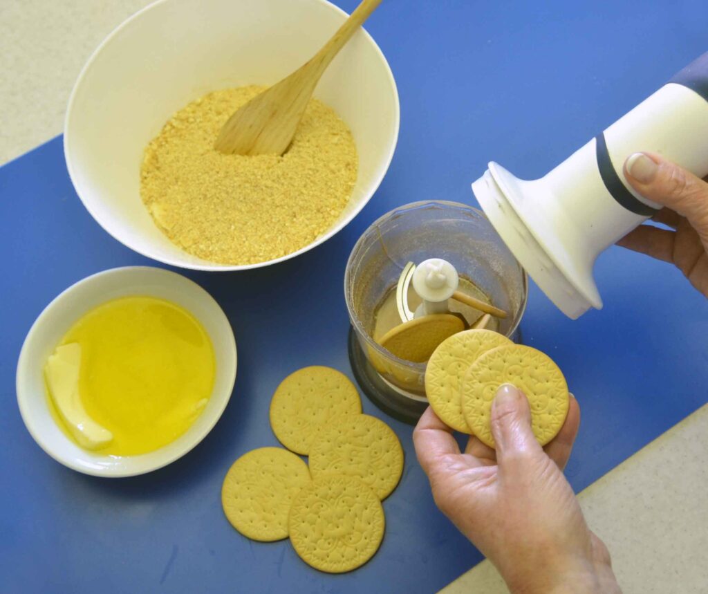 1. Máslové sušenky zpracujte v chopperu, případně je podrťte v sáčku ručním válečkem a drť propracujte s rozehřátým máslem